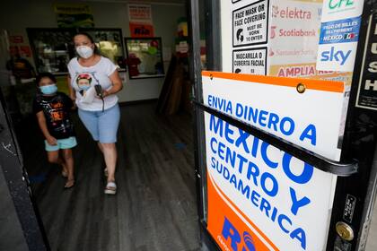 Archivo.- Una mujer sale de una tienda que ofrece servicios para enviar remesas a México y Centroamérica en San Diego, el 11 de septiembre de 2020
